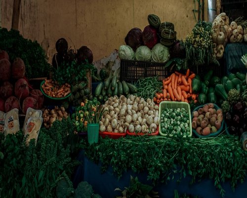 A collection of fresh local produce including avocados, beans, and fresh greens displayed at a regional marketplace